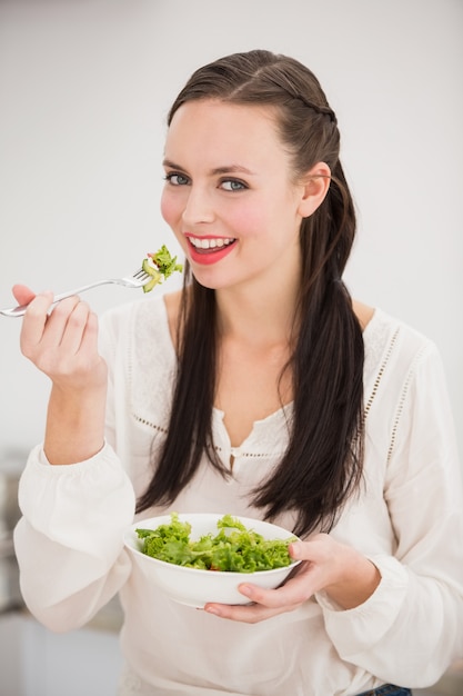 Mooi brunette die een gezonde salade voorbereiden