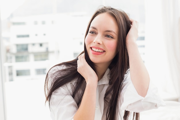 Mooi brunette die op bed glimlachen