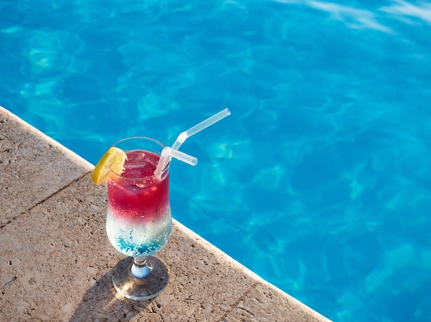 Mooi cocktailglas bij zwembad. Bovenaanzicht