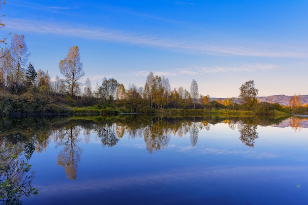 Mooi dalingslandschap met blauwe hemel weerspiegeld in het water