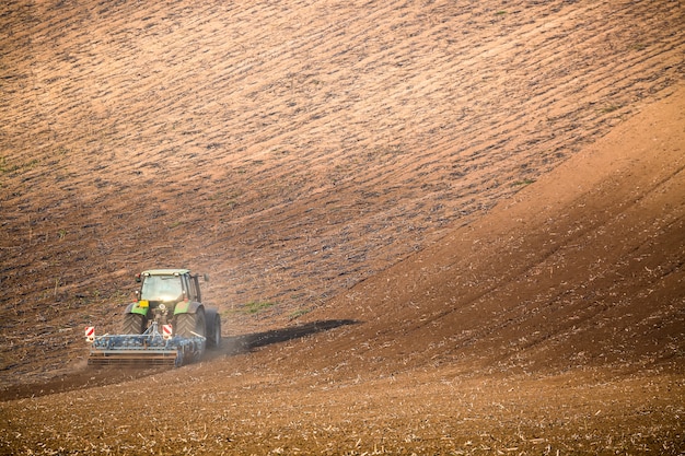 Mooi de herfstlandschap met werkende tractor in Zuid-Moravië, Tsjechische Republiek,