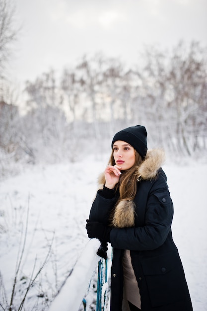 Mooi donkerbruin meisje in de winter warme kleding. Model op winterjas en zwarte hoed.