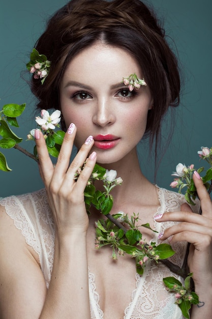 Mooi donkerbruin meisje met een zachte romantische make-up roze lippen en bloemen