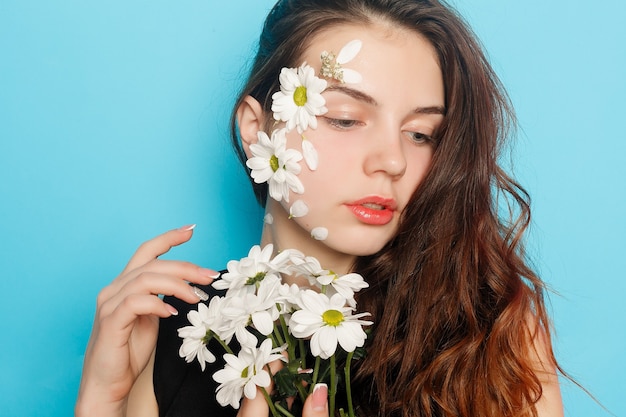 Mooi donkerbruin meisje met groene ogen met bloemen