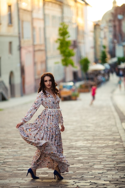 Mooi donkerbruin sexy toeristenmeisje die op drukke stadsstraat lopen met lang haar die in de wind vliegen.