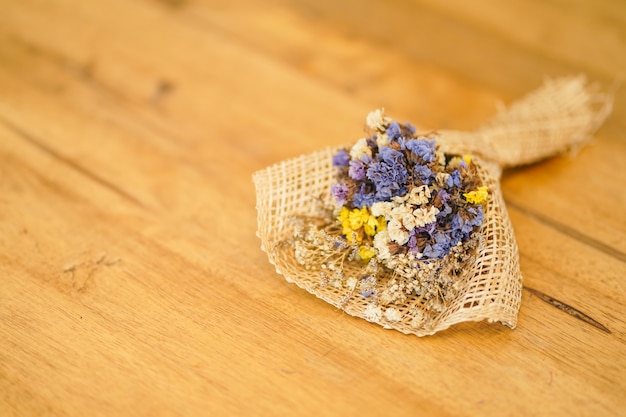 Foto mooi droog bloemboeket dat op een houten lijst, een boeket van bloemen wordt geplaatst