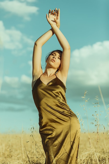 mooi elegant model bij zonsondergang in een maïsveld met elegante jurk