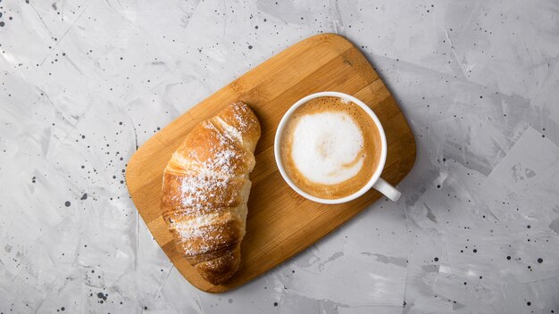 Mooi en eenvoudig traditioneel Frans ontbijt met verse croissants en een kopje cappuccino