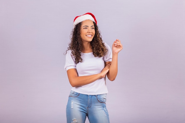 Mooi en vrolijk meisje met kerstman hoed wijzend naar vrije ruimte voor tekst.