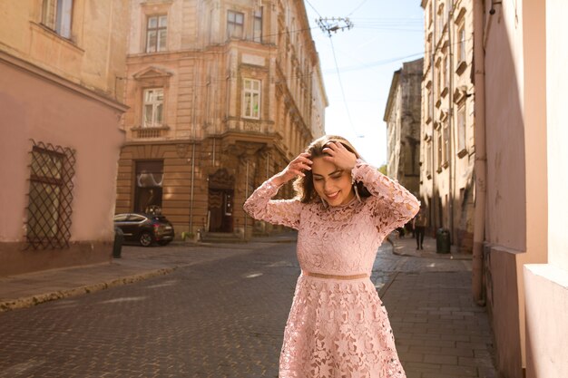 Mooi gebruind model poserend in modieuze kleding op straat