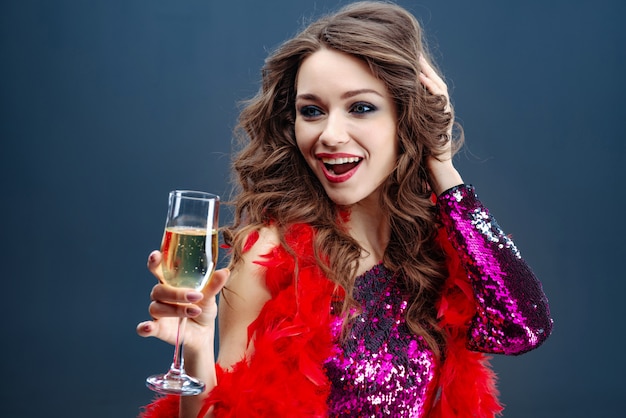 Foto mooi glamourvrouw het vieren holdingsglas champagne