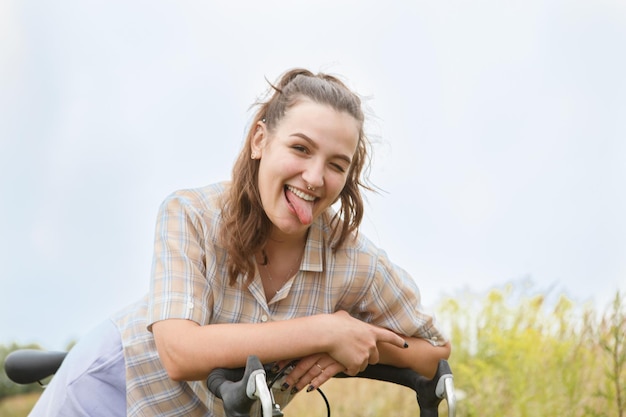 Mooi glimlachend jong vrouwenportret met fiets in een landweg