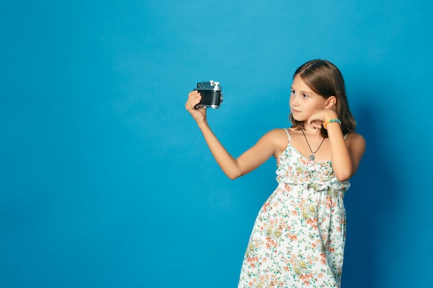 Mooi glimlachend kind (meisje) met witte tanden die een camera houden en selfie maken