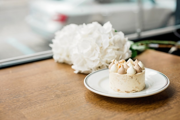 Mooi heerlijk dessert op tafel. Geniet van een vers gebakken dessert in een koffieshop, restaurant. Een close-up shot van een kleine zoete decoratieve cake. Zachte selectieve focus.