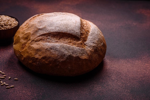 Mooi heerlijk versgebakken rond gevormd witbrood op een donkere betonnen achtergrond