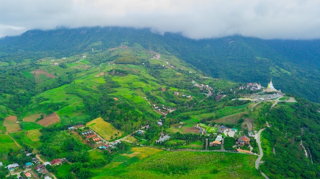 Mooi heuvelsdorp onder het overzees van wolken in thailand.