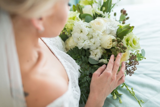 mooi huwelijksboeket met verschillende bloemen op de handen van de bruid.