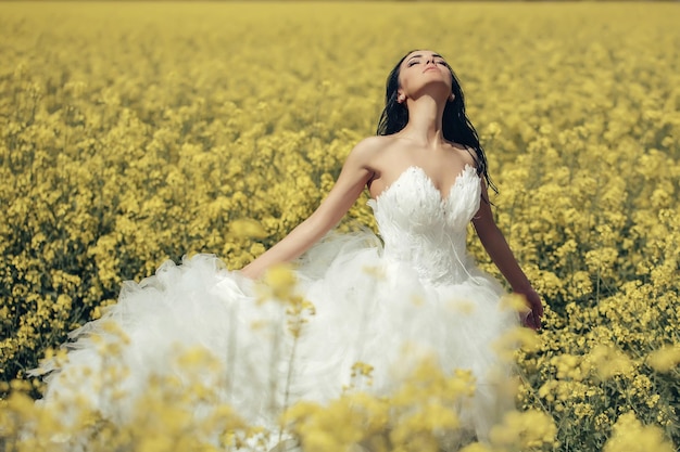 Mooi huwelijksmeisje in gele veldbloemen