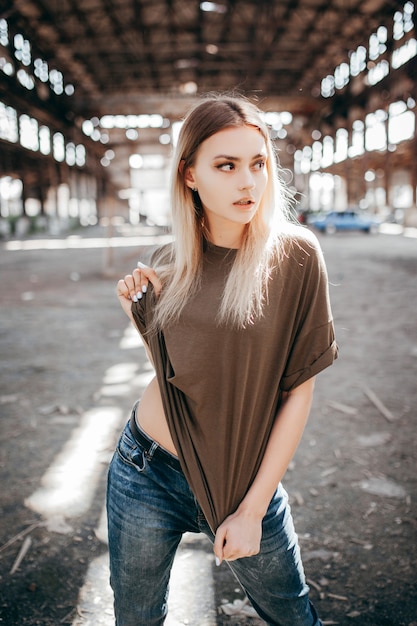 Mooi jong blondemeisje in een leeg groen T-shirt