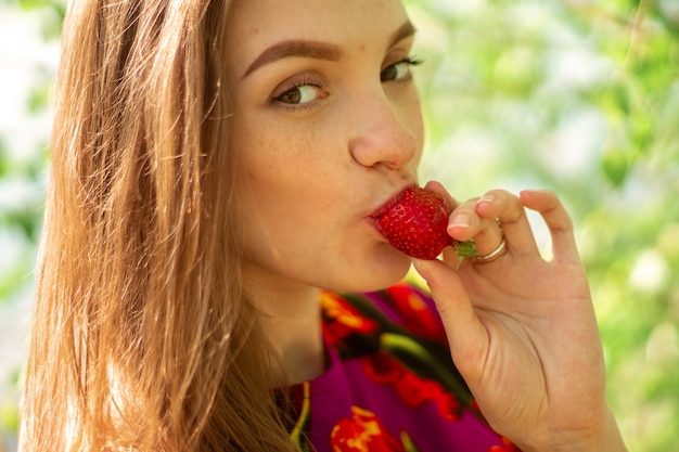 Mooi jong meisje dat aardbeien eet