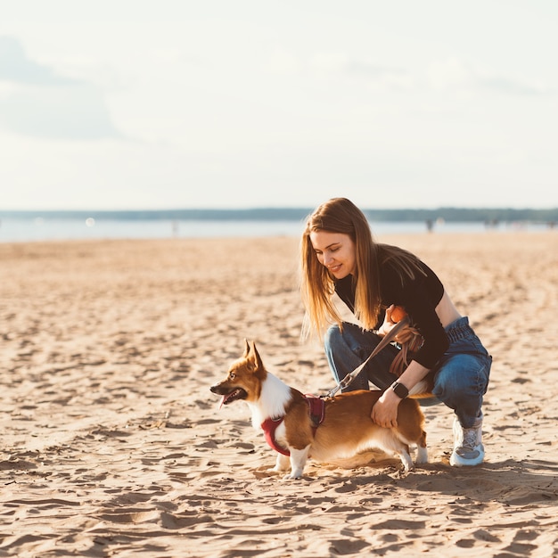 Mooi jong meisje dat corgipuppy aait