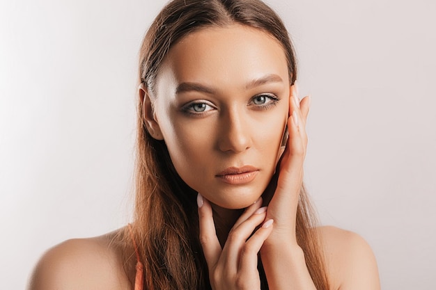 Mooi jong meisje glimlachend en poseren kijkend naar de camera op een witte geïsoleerde achtergrond met mockup Positieve brunette vrouw Vriendelijke blik Schoonheid gezicht