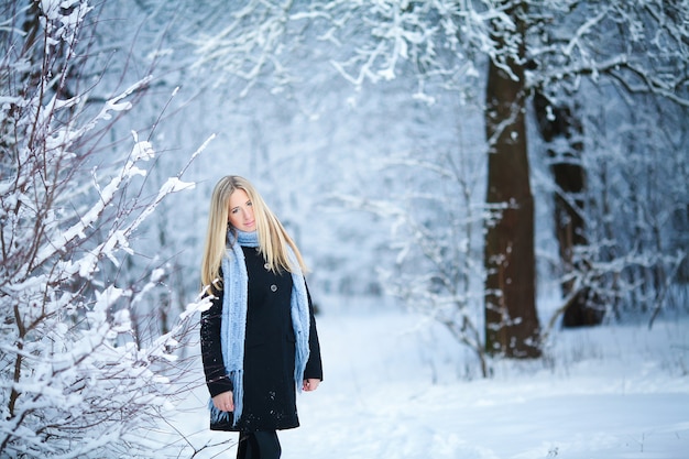 Mooi jong meisje glimlachend en wandelen in de straat. mooie besneeuwde koude winter. vakantiestemming.