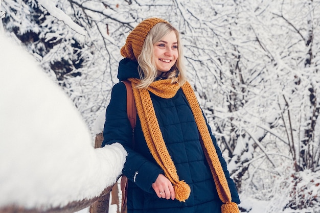 Mooi jong meisje in een winterpark loopt in het winterbos.