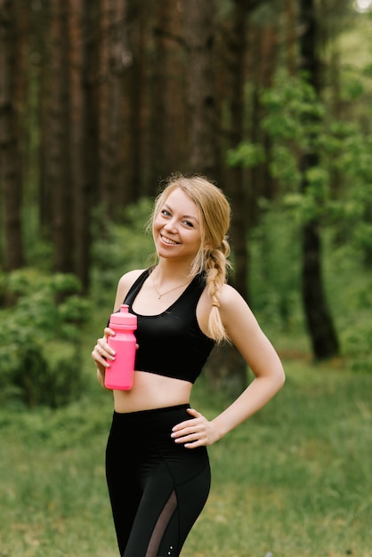 Mooi jong meisje in sportkleding drinkwater