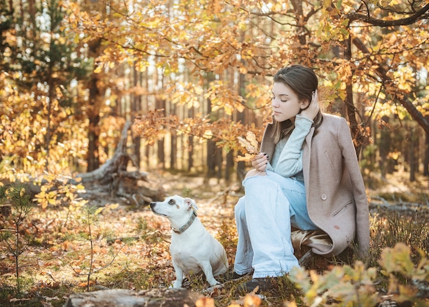 Mooi Jong Meisje Met Haar Hond In Het Bos. Herfst bos.