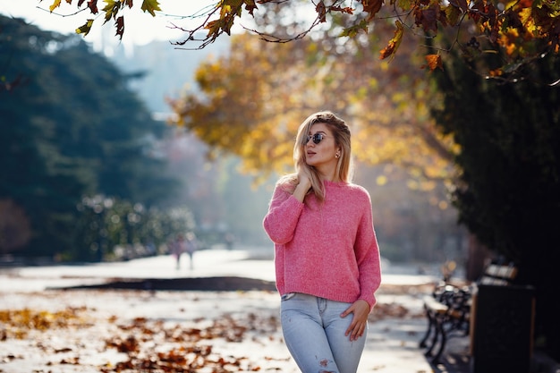 Foto mooi jong meisje op een wandeling in de herfststad mooie vrouw in een trui mode portret stijlvolle mooie vrouw buiten jonge vrouw die plezier heeft in de stad straatmode