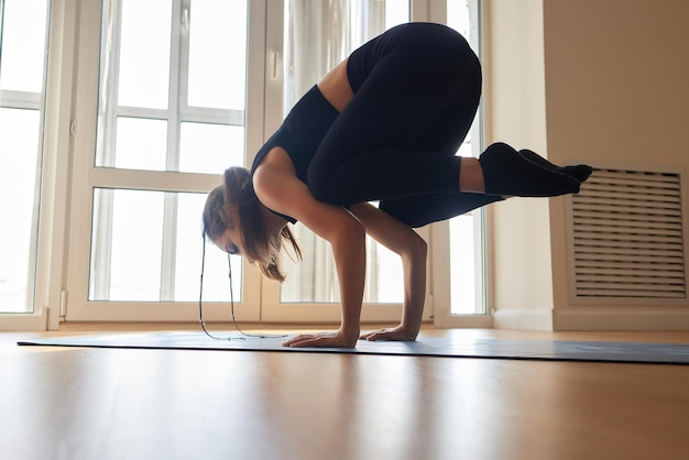 Mooi jong model dat thuis aan het trainen is en fitnessoefening doet op de vloer paripurna navasana voor upp