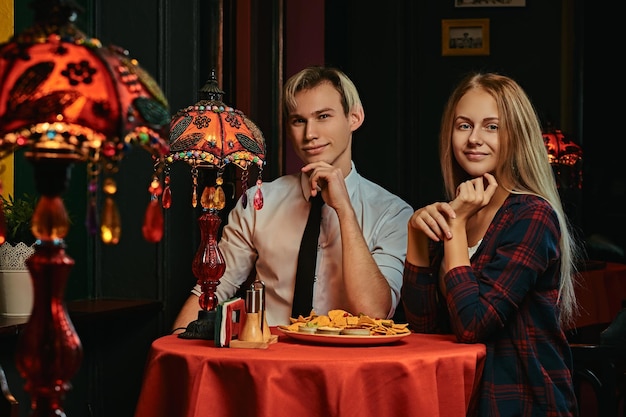 Mooi jong stel bestelde nacho's tijdens het daten in een Mexicaans restaurant.