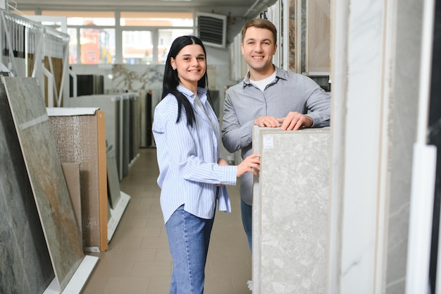 Mooi jong stel dat keramische tegels kiest voor de reparatie van hun huis in de bouwwinkel