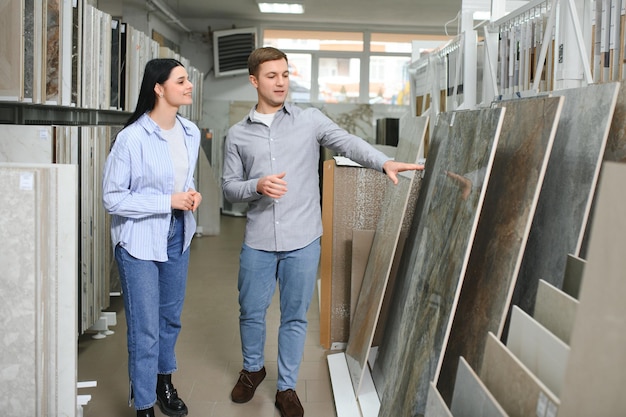 Mooi jong stel dat keramische tegels kiest voor de reparatie van hun huis in de bouwwinkel