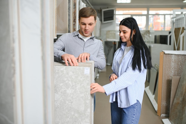 Mooi jong stel dat keramische tegels kiest voor de reparatie van hun huis in de bouwwinkel