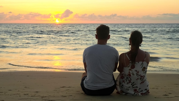 Mooi jong stel zit op oceaanstrand