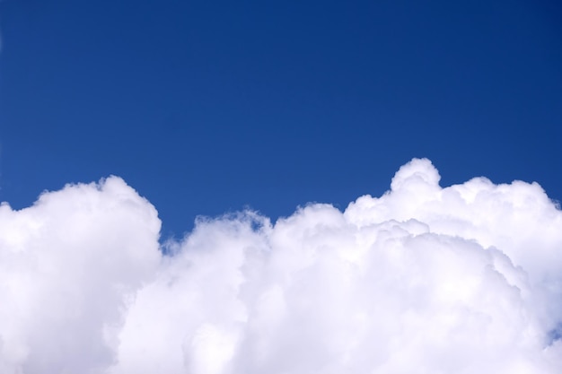 Mooi kalm luchtlandschap met witte wolken onderaan de foto en blauwe lucht met kleurovergang