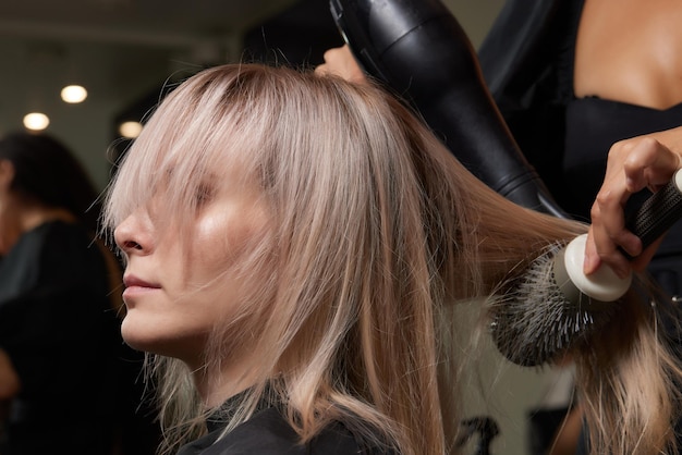 Mooi kapsel van jonge vrouw na het verven van haar en het maken van highlights in de kapsalon