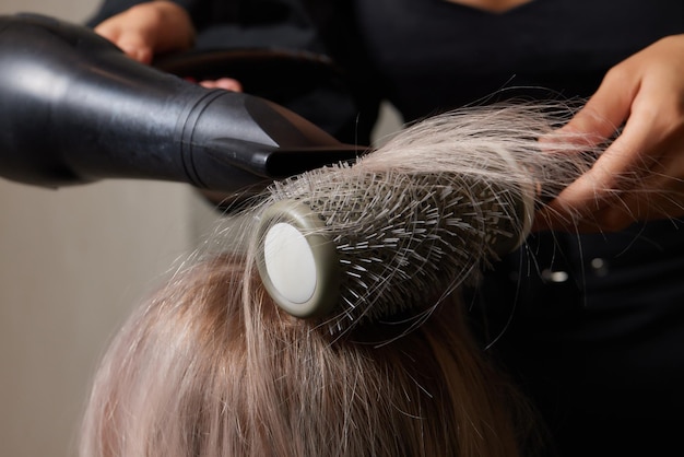 Mooi kapsel van jonge vrouw na het verven van haar en het maken van highlights in de kapsalon