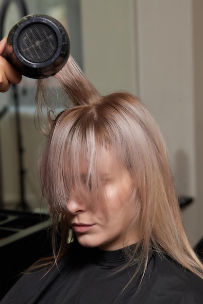 Mooi kapsel van jonge vrouw na het verven van haar en het maken van highlights in de kapsalon