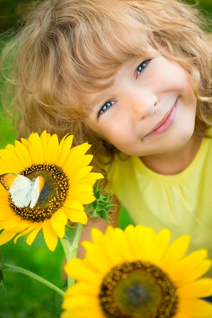 Mooi kind met vlinder in lentepark Gelukkig kind buiten spelen