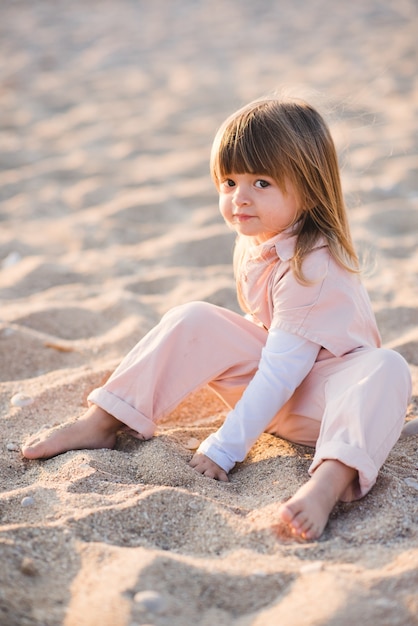 Mooi klein kind spelen met zand op het strand over zee