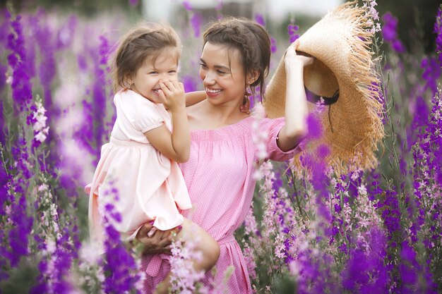 Mooi klein meisje en haar moeder met bloemen. Familie buitenshuis