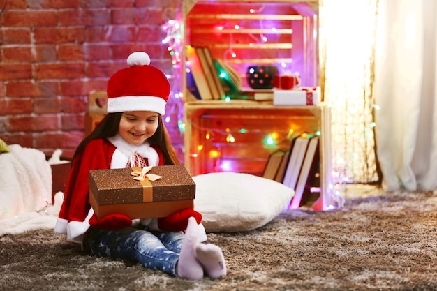 Mooi klein meisje in Carnaval kostuum zittend in kerst ingerichte kamer