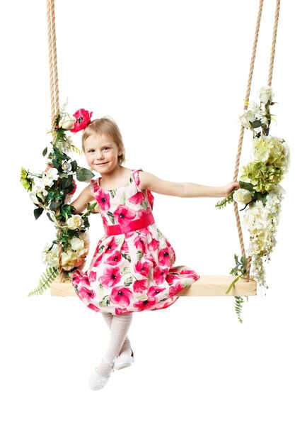 Mooi klein meisje swingend op een schommel Het concept van gezinsgeluk zomervakantie geïsoleerd op witte achtergrond