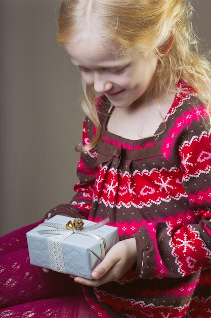 Mooi lachend meisje dat cadeautjes in handen houdt