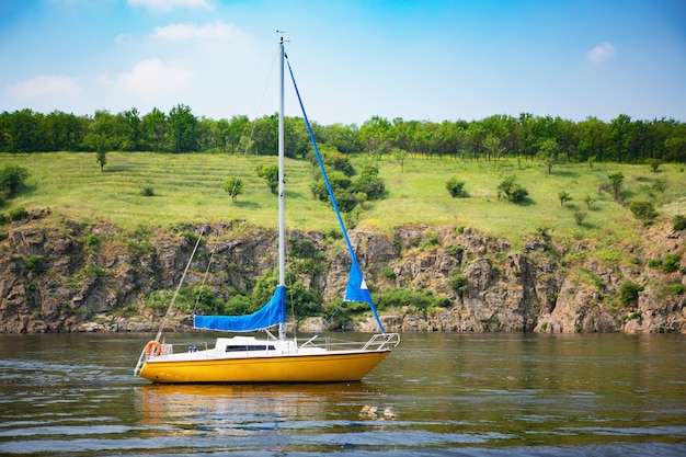 Mooi landschap van zeiljacht met rotsachtige kust.