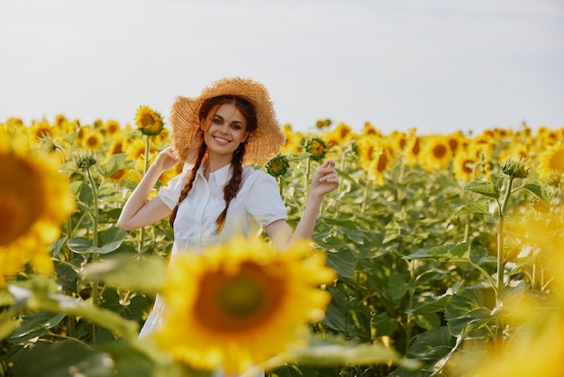 Mooi lief meisje in een hoed op een veld met ongewijzigde zonnebloemen