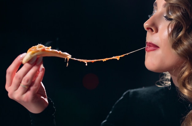 Mooi meisje alleen eten van pizza in een restaurant.